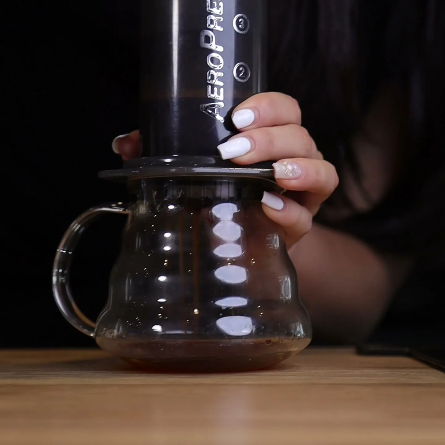 Presionando el émbolo de la AeroPress Original sobre una jarra de cristal