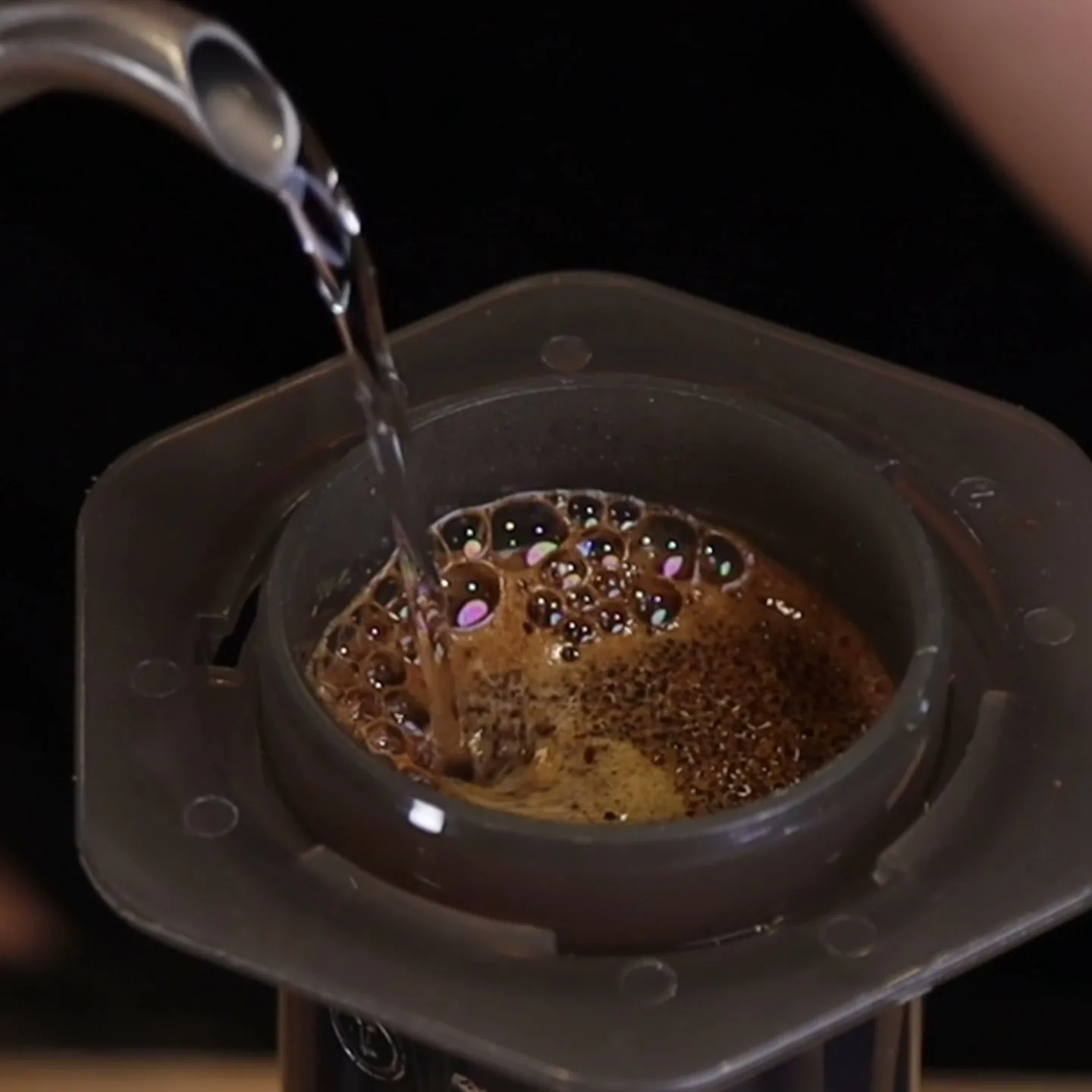 Vertido del agua caliente sobre el café molido dentro de la AeroPress Original