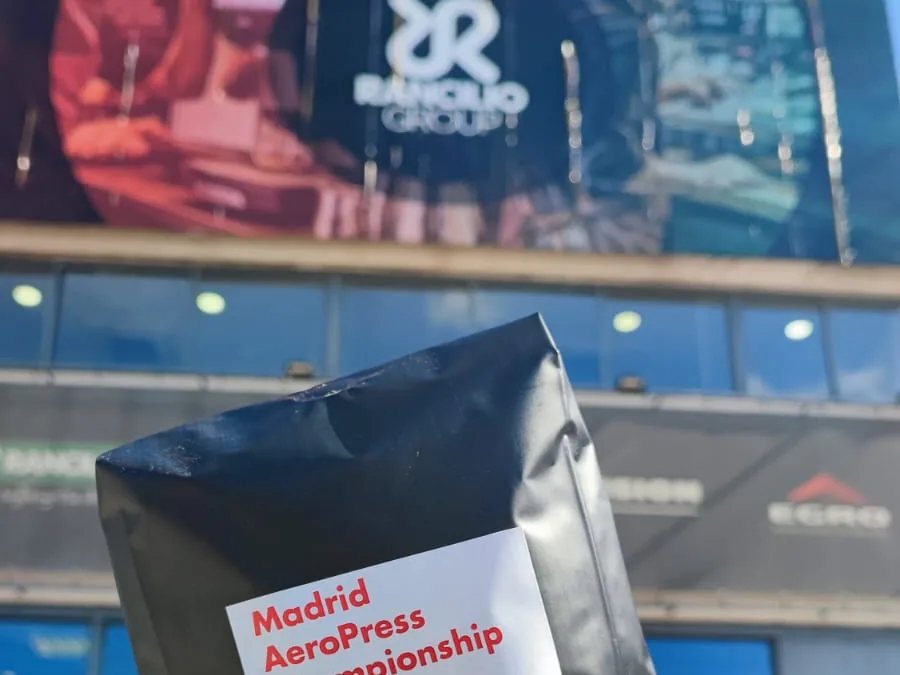 Una mano sostiene una bolsa negra del campeonato ante la fachada de Rancilio Group.