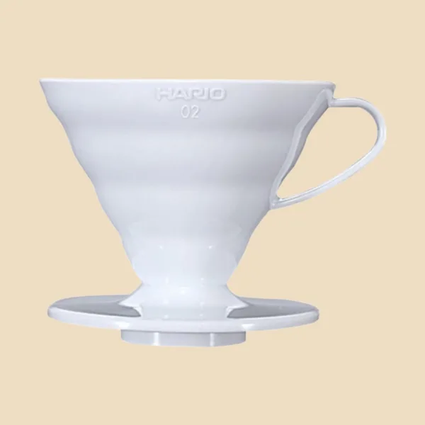 Hario V60 02 blanco visto de frente sobre fondo arena