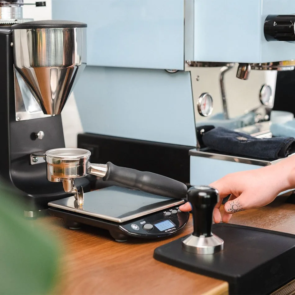 Café molido dosificado en un portafiltros colocado sobre la Rhino Bench Scale RCGPORT2KG