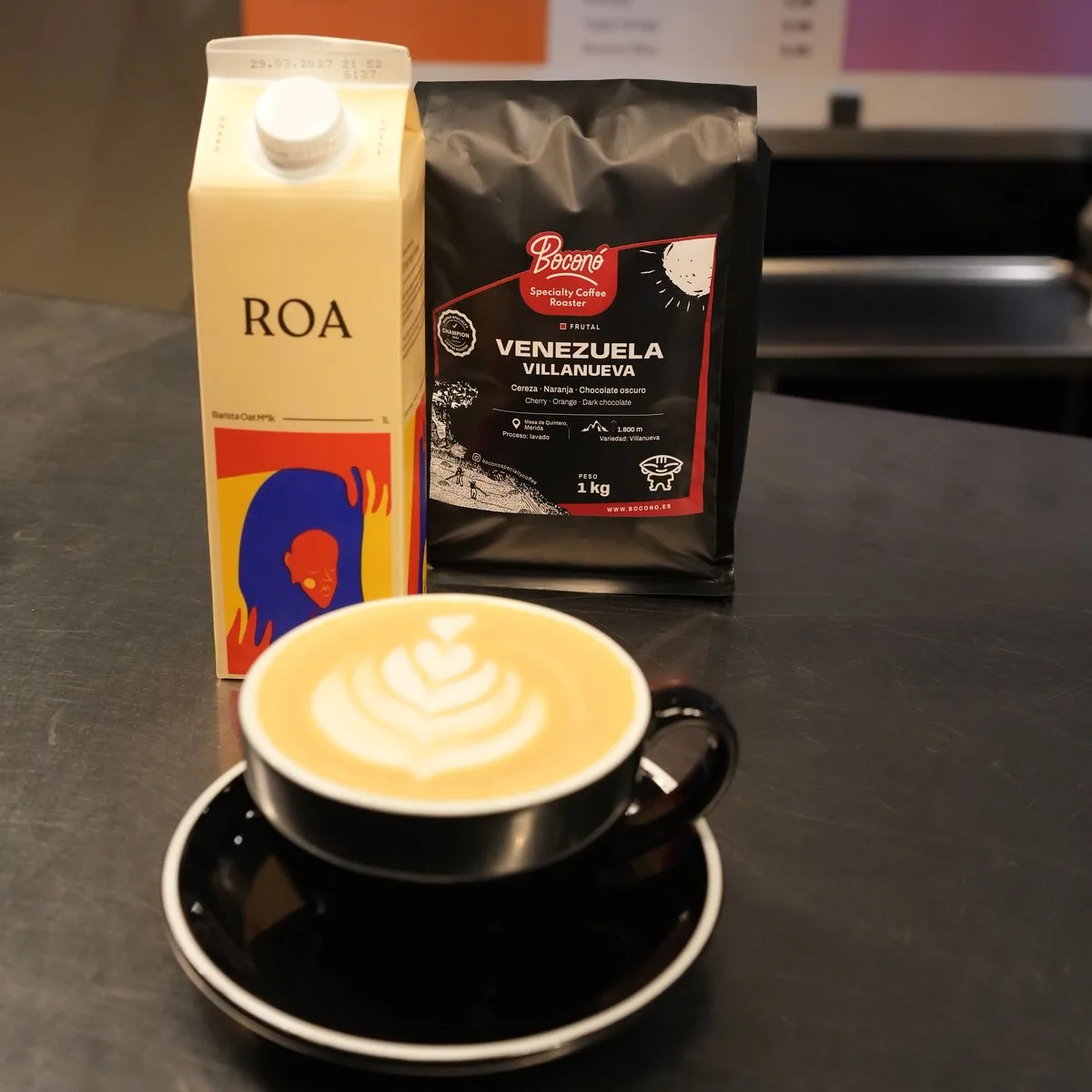 Latte con bebida de avena ROA Barista junto al brik y una bolsa de café de Venezuela de Boconó