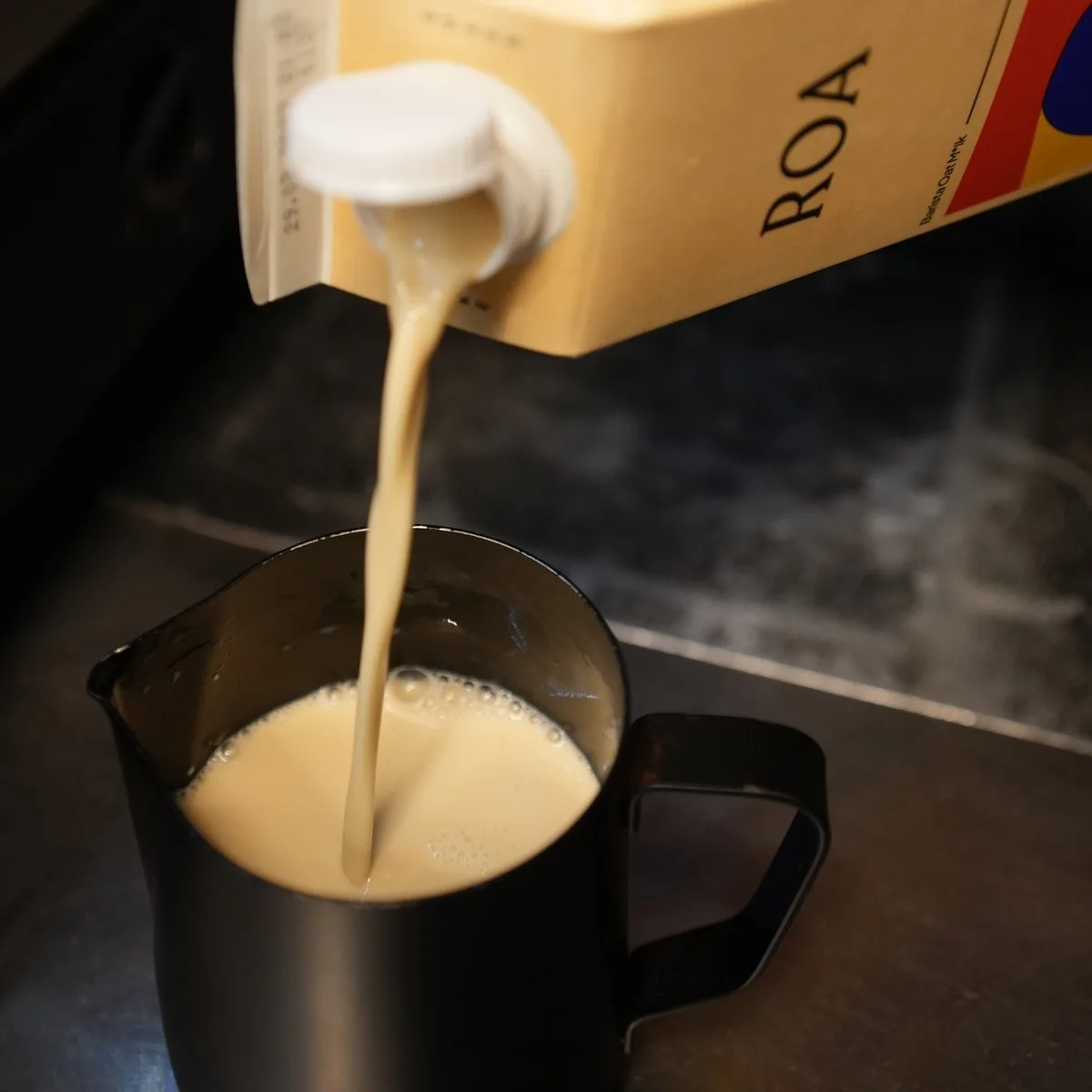 Bebida de avena ROA Barista vertida desde el brik en una jarra de vaporizar