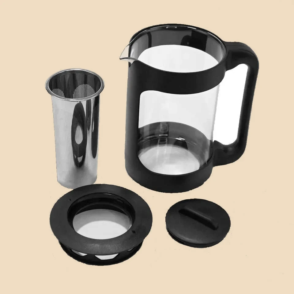 La jarra de cold brew despiezada: cuerpo de vidrio, filtro cilíndrico de malla y las dos tapas.