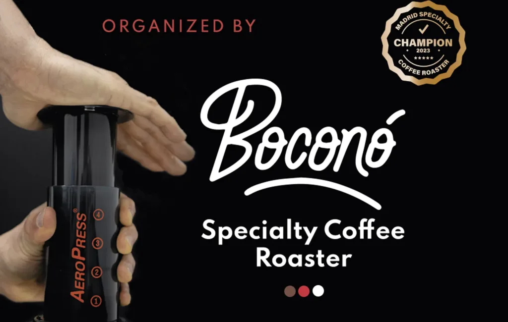 Una mano prensa el émbolo de una AeroPress, junto al logotipo de Boconó Specialty Coffee Roaster y el sello de campeón tostador de café de especialidad de Madrid 2023