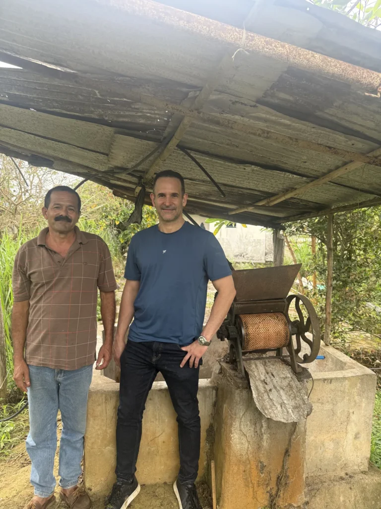 Enrique Rondón junto a la despulpadora de hierro y el tanque de fermentación de la finca