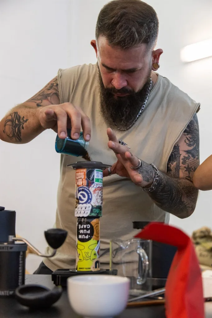 Competidor volcando el café molido desde un vaso dentro de la AeroPress