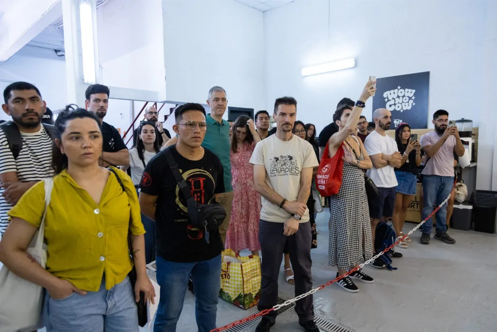 Grupo de asistentes de pie siguiendo la competición dentro del tostadero