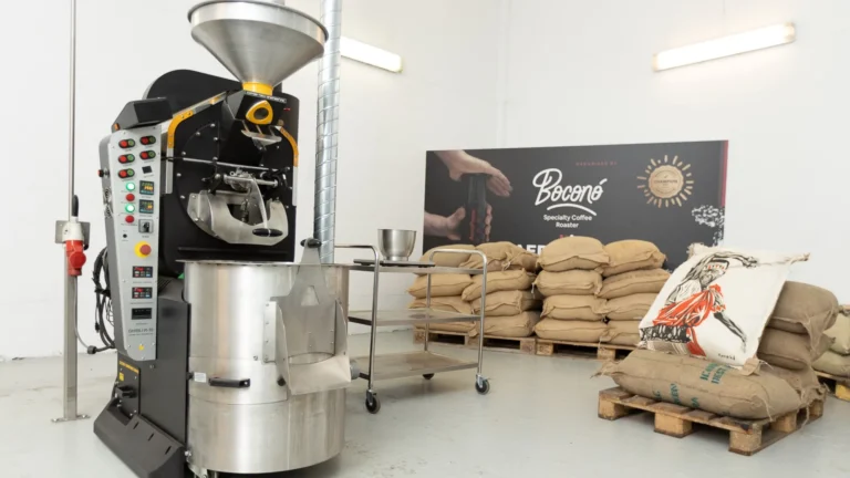 Tostadero de Boconó en Madrid, con el tostador Coffee-Tech, los sacos de café verde sobre palés y el cartel de la marca al fondo