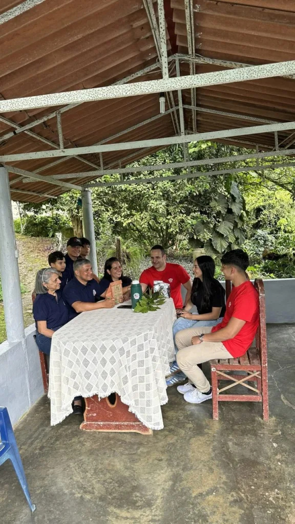 El equipo de Boconó a la mesa con los productores de la Hacienda Los Luises, bajo el tejado de la finca en Bizcocuy (Venezuela)